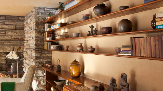 A photo of art and ceramics on the shelves of the guest house living room at Fallingwater