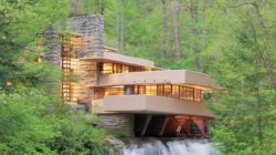 The Fallingwater house in spring with interior lights illuminated.