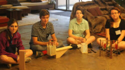 High school students sit on the flagstone floor of the living room at Fallingwater with projects made during one of Fallingwater Institute's High School Residency programs.