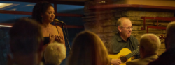 Vocalist Gloria Reuben and Guitarist Marty Ashby perform in the living room of Fallingwater as a crowd enjoys their performance.