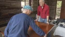 Wood conservators remove a desk from the exterior wall.