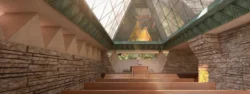 A computer rendering of a chapel interior. Stacked stone and stucco walls are capped with a patina green cooper band with a geometric motif and a steeply pitched glass roof made of many triangular glass panes. Rows of wooden pews extend toward the pulpit in the background.