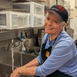 Fallingwater volunteer Sharon Dinicola washes dishes in the Cafe at Fallingwater.