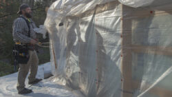 Maintenance Specialist Ben Morrison carefully “unwraps” Fallingwater’s plastic enclosures from above the East Terrace and trellis.