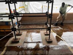 Member of the preservation team applying epoxy coating to the roof