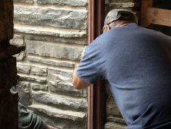 Carefully removing the masonry surrounding the window frame